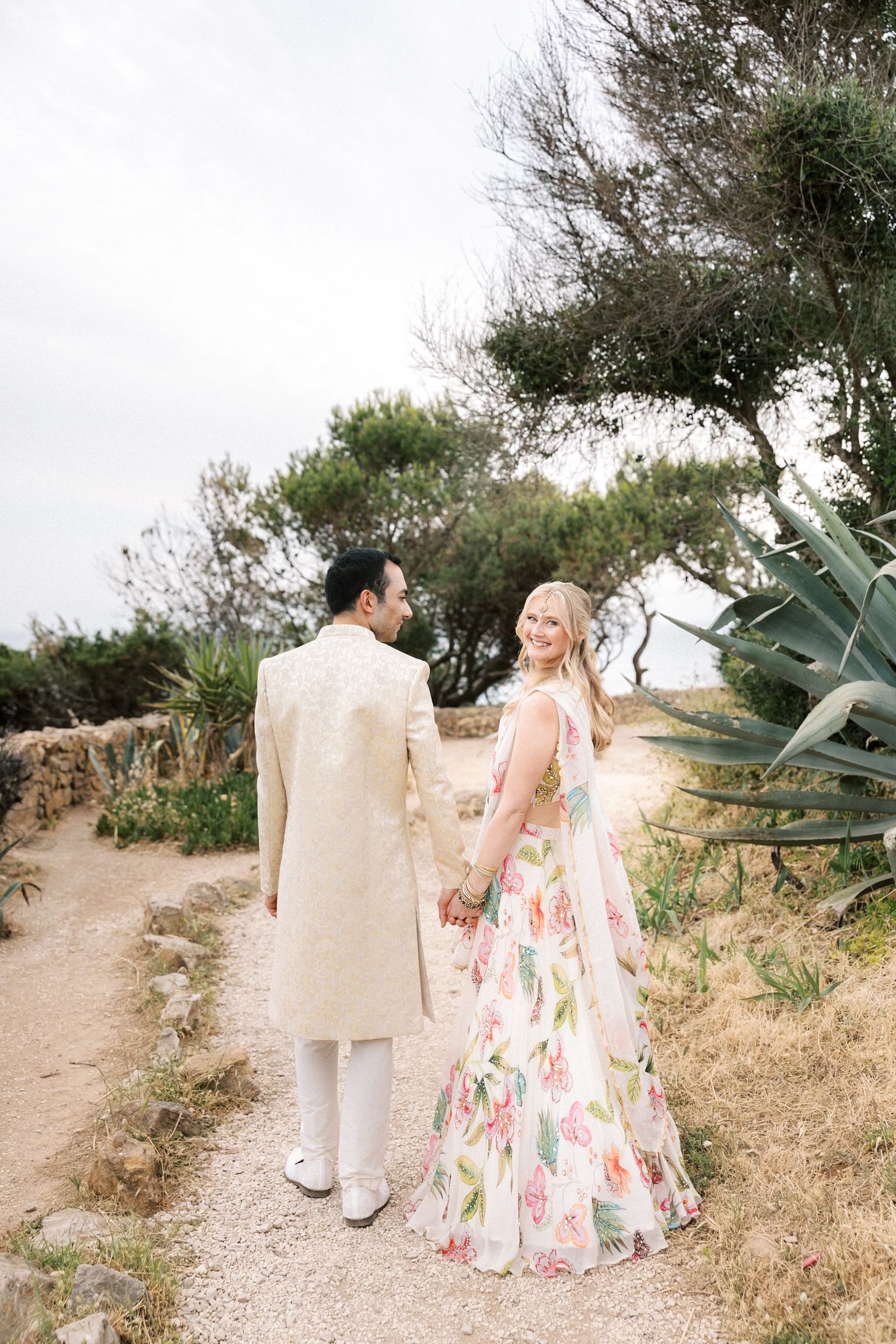 Bride and groom holding hands during a seaside Mehndi and Sangeet portrait session at Casa da Guia overlooking the Atlantic Ocean.