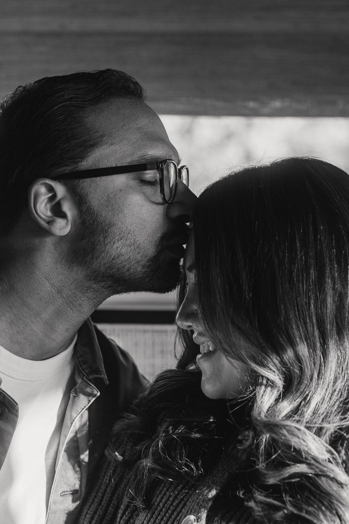 Black and white close up of Rohan kissing Amanda’s forehead during their maternity photoshoot