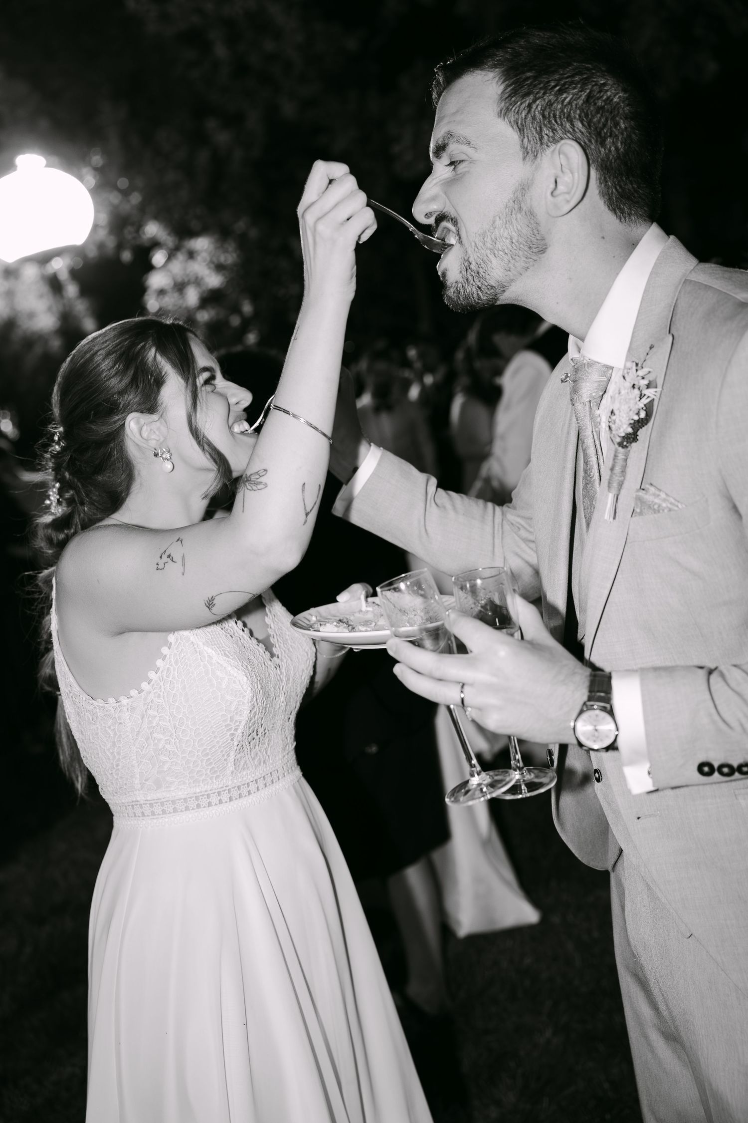 foto a preto e branco da noiva a dar o bolo de casamento ao noivo