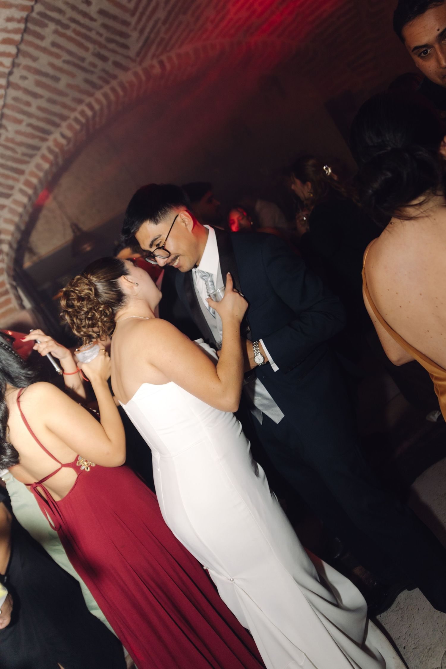 Bride and groom sharing a romantic kiss on the dance floor at their wedding reception.