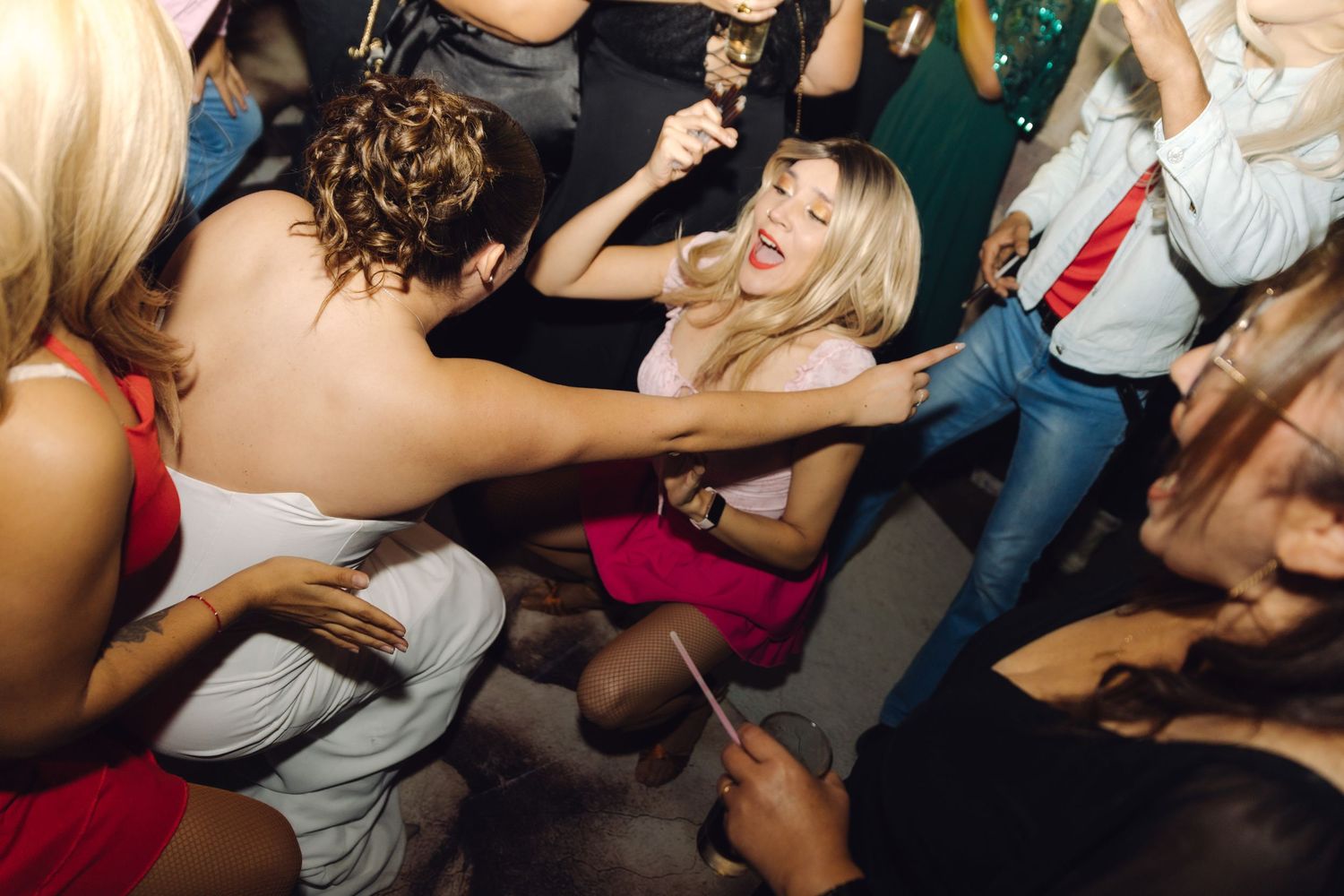 Energetic wedding guests dance and celebrate together on a lively reception dance floor.
