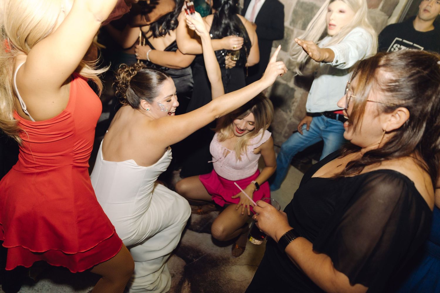 Wedding guests dance and celebrate together on the dance floor at evening reception.