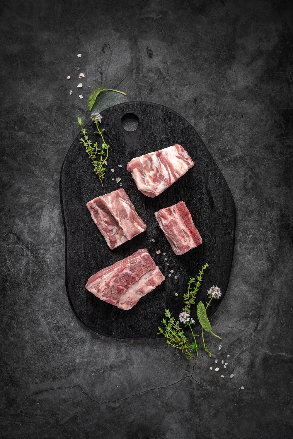 Mangalica pork backbone by Fekete Zsóka in a moody dark flatlay with rustic wood and stone styling, © Reka Peurala, Three Pod Studio
