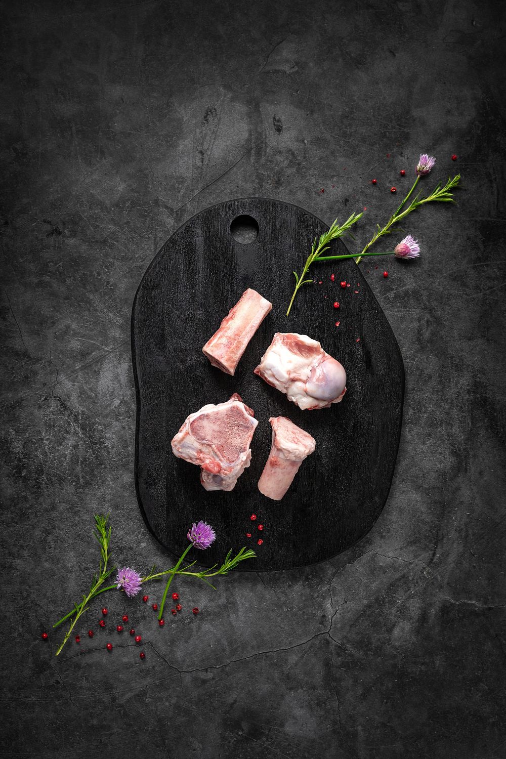 Mixed mangalica meaty pork bones by Fekete Zsóka in a moody dark flatlay with rustic wood and stone styling, © Reka Peurala, Three Pod Studi