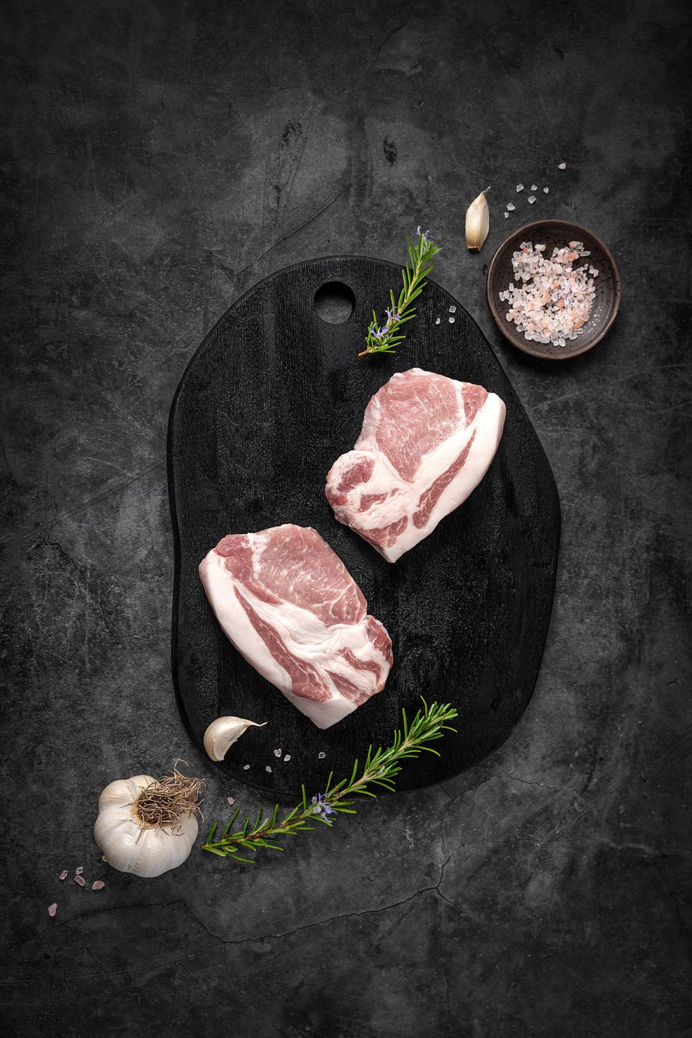 Mangalica pork meat by Fekete Zsóka in a moody dark flatlay with rustic wood and stone styling, © Reka Peurala, Three Pod Studio