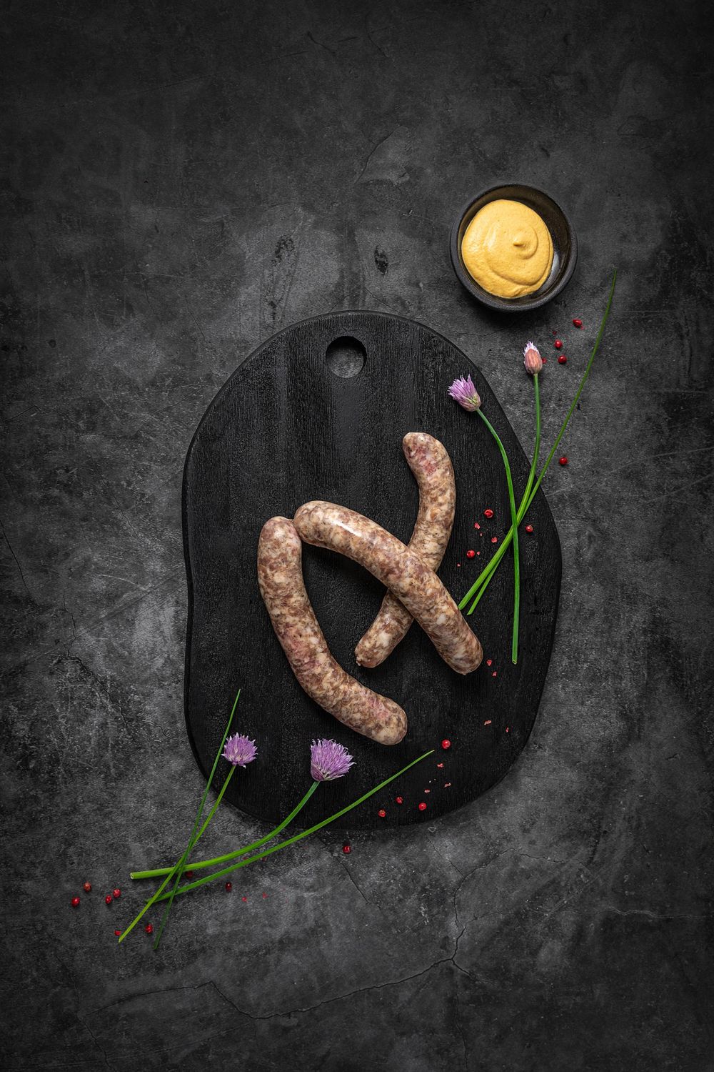 Mangalica grill sausage by Fekete Zsóka in a moody dark flatlay with rustic wood and stone styling, © Reka Peurala, Three Pod Studio