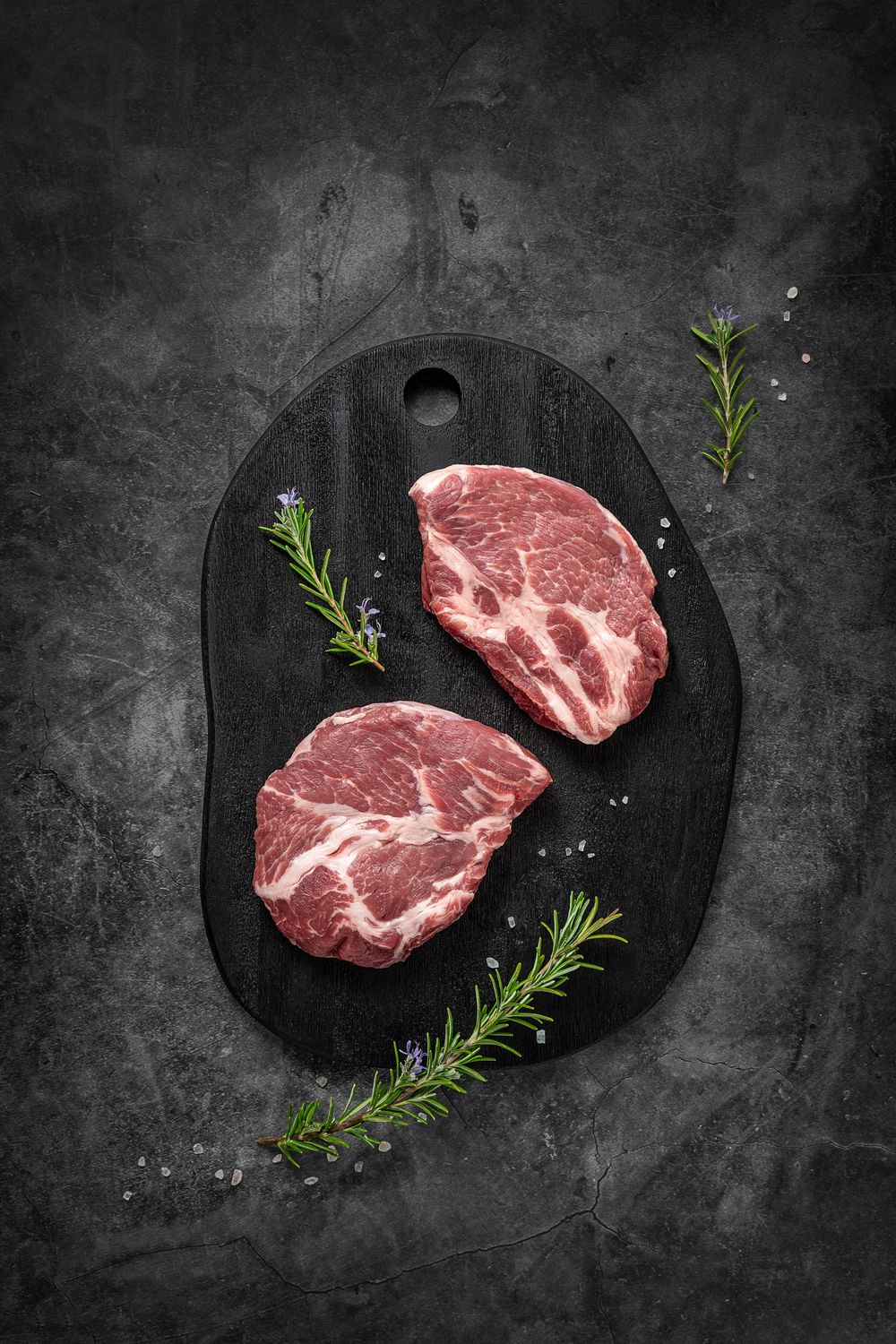 Mangalica pork shoulder by Fekete Zsóka in a moody dark flatlay with rustic wood and stone styling, © Reka Peurala, Three Pod Studio