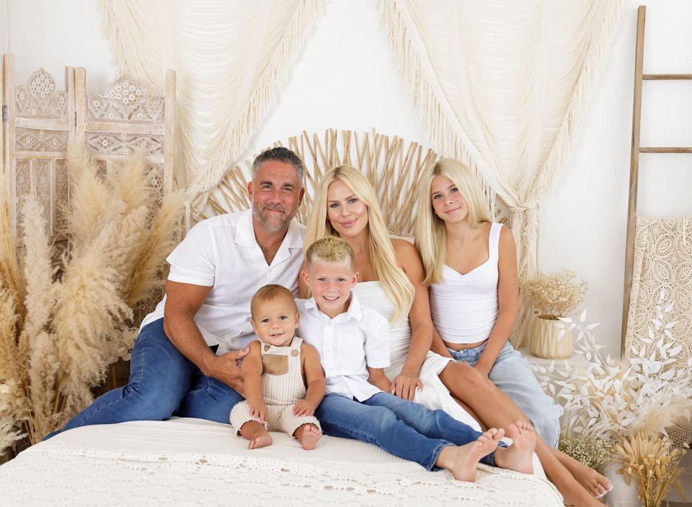 Light and airy indoor family photo session with neutral decor and pampas grass accents.