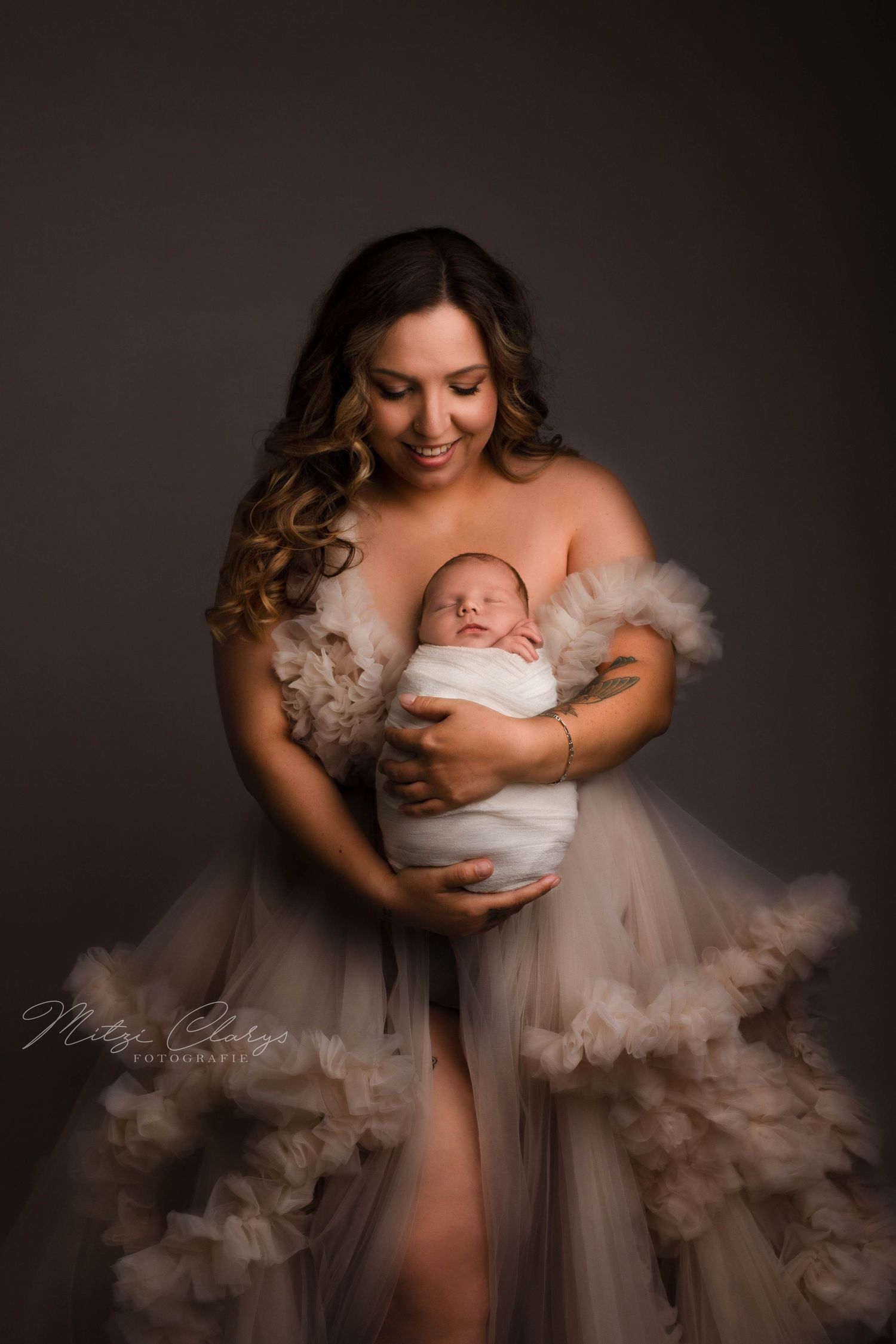 Mama in grote jurk en baby in zachte wrap tijdens newborn fotoshoot in Goes