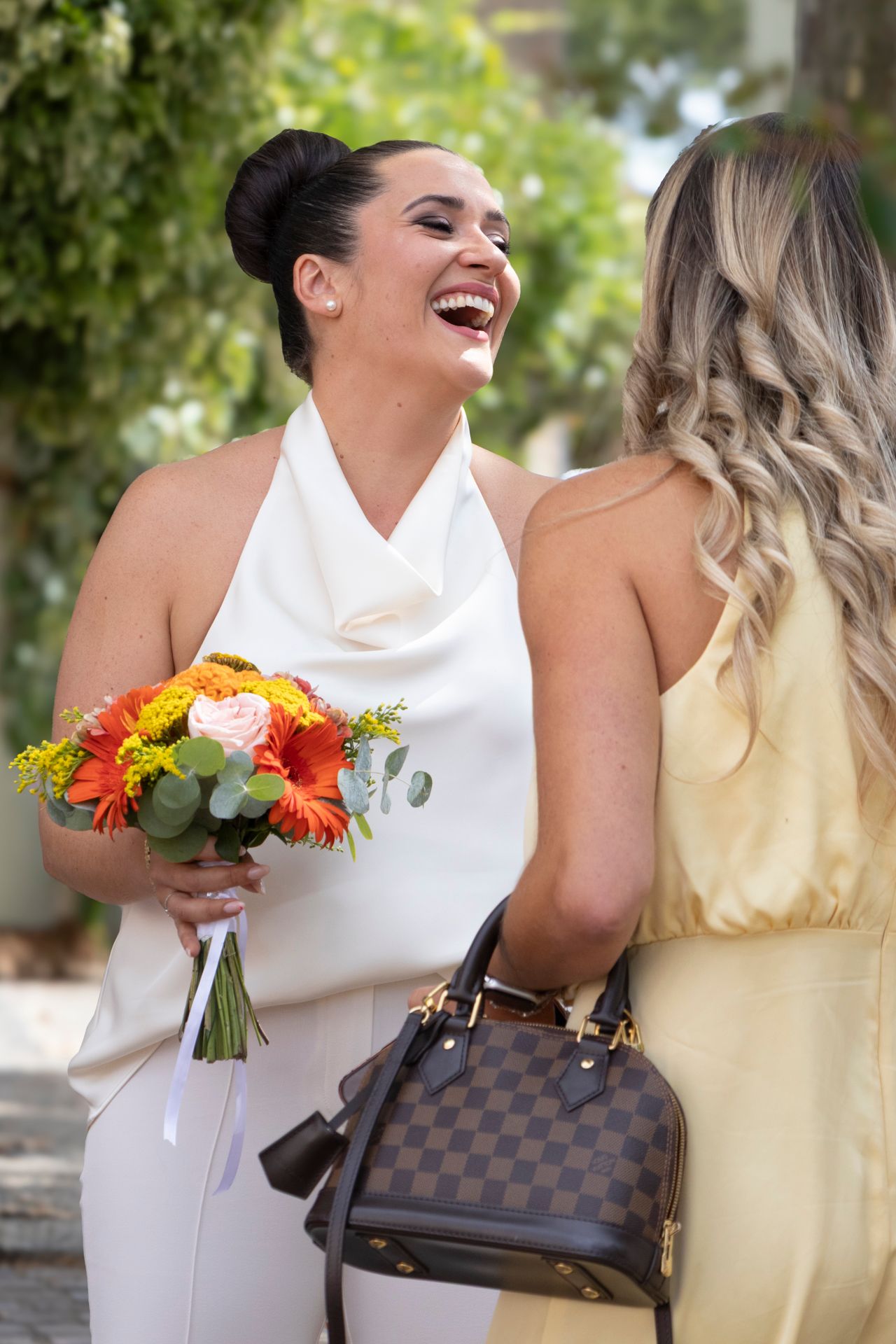 Mariée éclatant de rire avec son bouquet de fleurs colorées, échangeant avec une invitée, Lyon