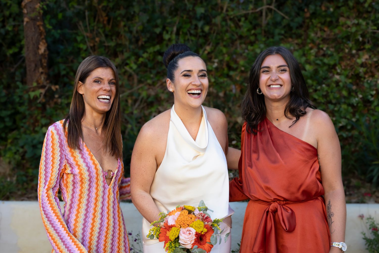 Mariée avec son bouquet entourée de deux amies rieuses en robes colorées, mariage civil à Lyon