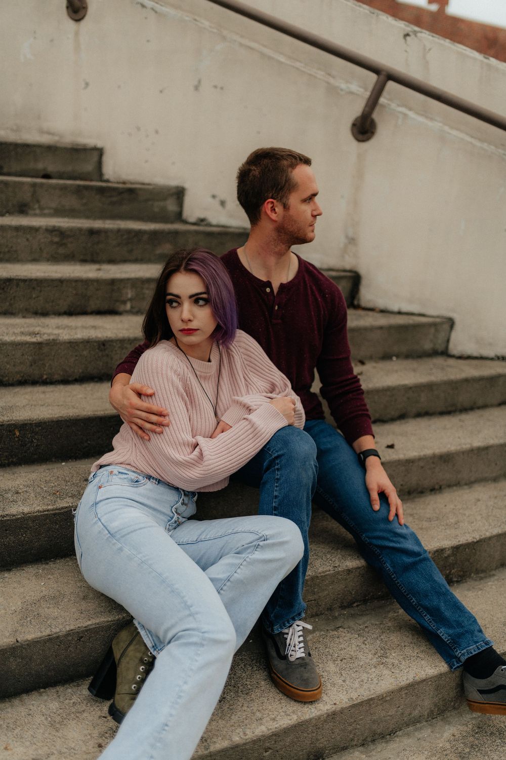 A couple in cozy sweaters sitting together on urban steps during a Rome GA portrait session by Ella Monroe Photography