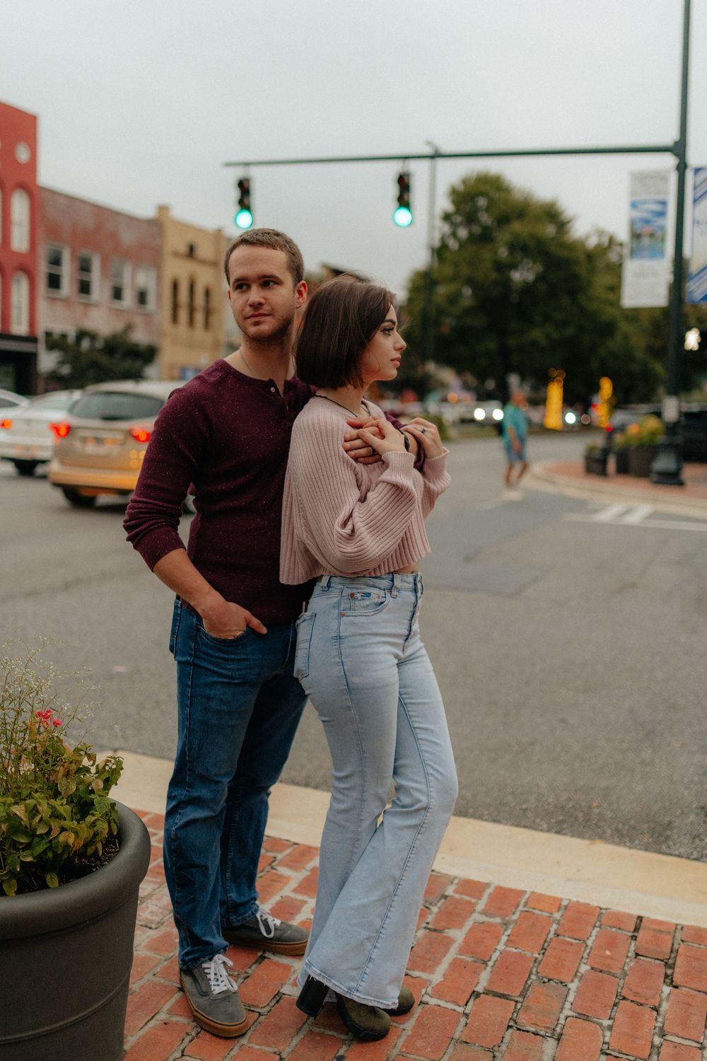 A young couple posing on a street corner during a lifestyle couples session in Rome, GA by Ella Monroe Photography.