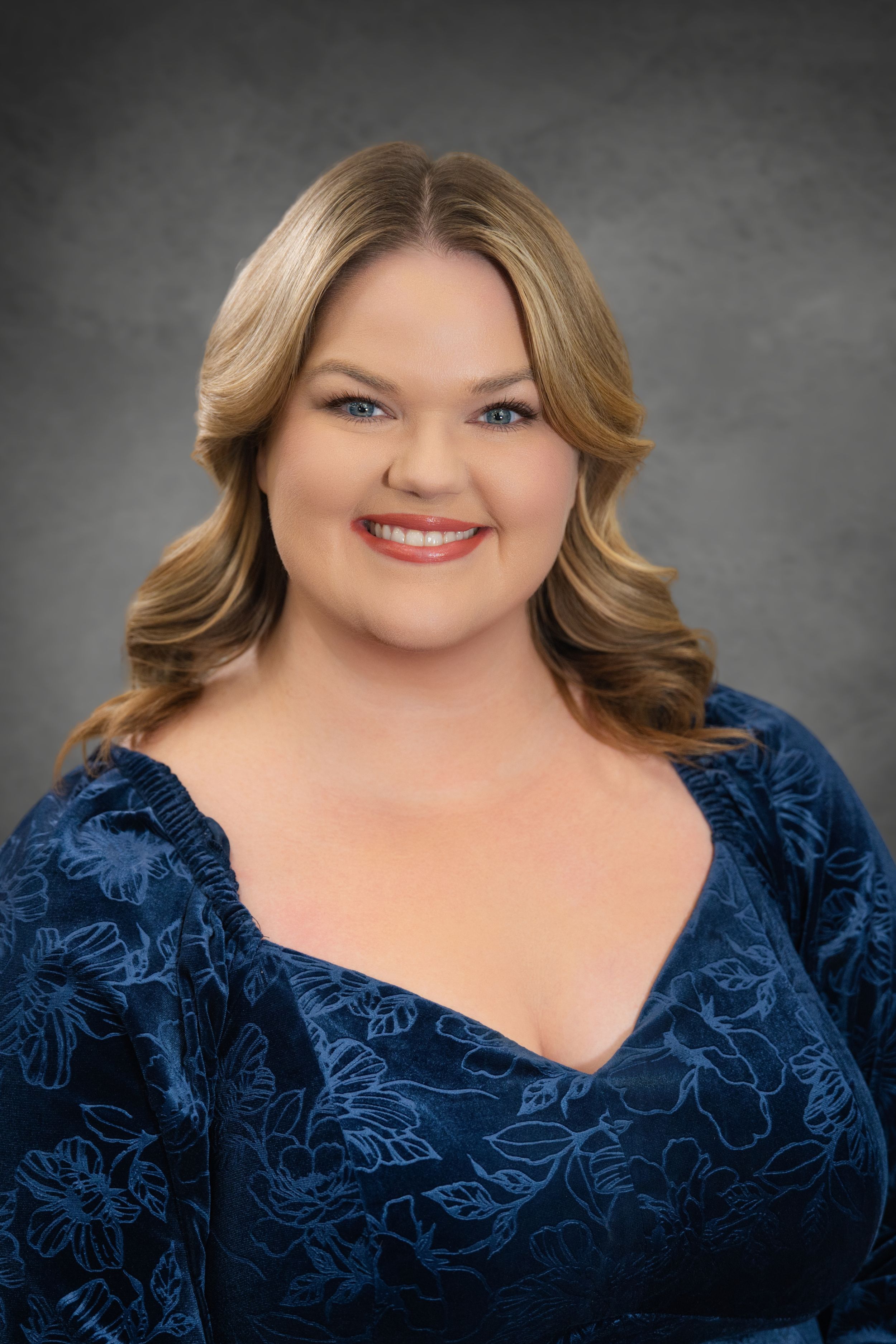 Ashley Smith Professional headshot against a gray background.  Quad Cities Photography