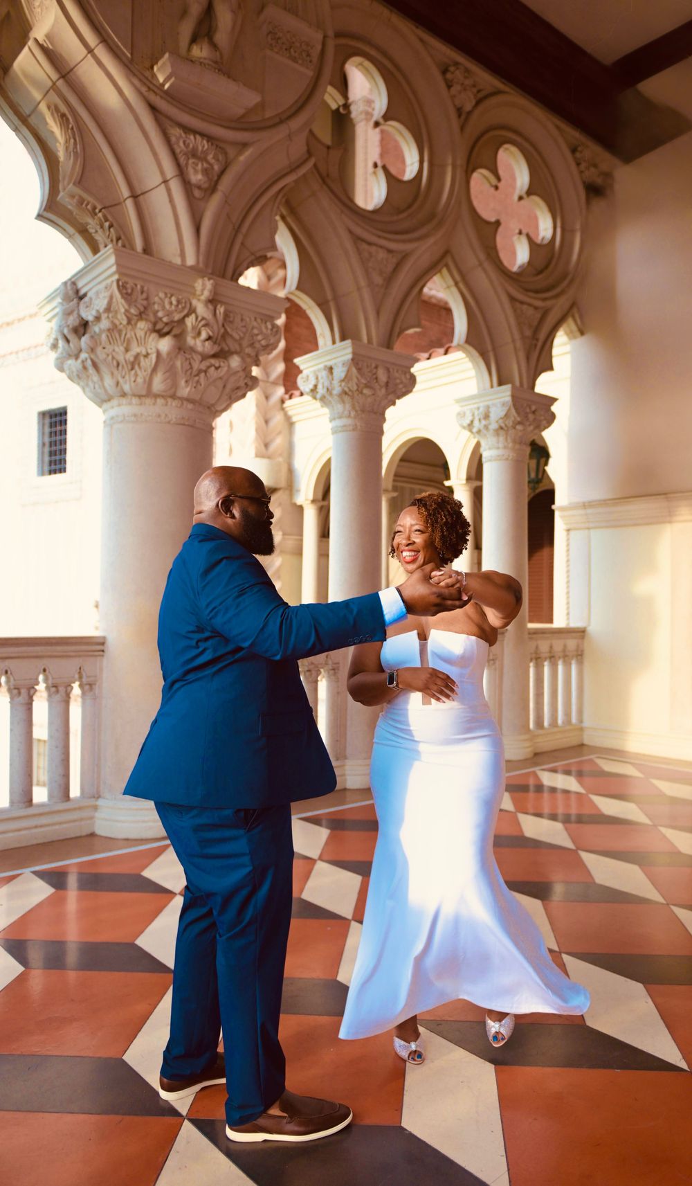 Bride and groom dancing joyfully inside The Venetian Las Vegas ornate arcade with marble floors.