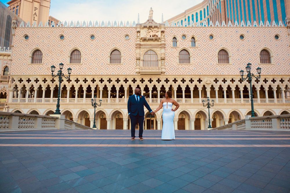 Couple holding hands in front of the Venetian Resort Las Vegas, showcasing its grand Italian architecture.
