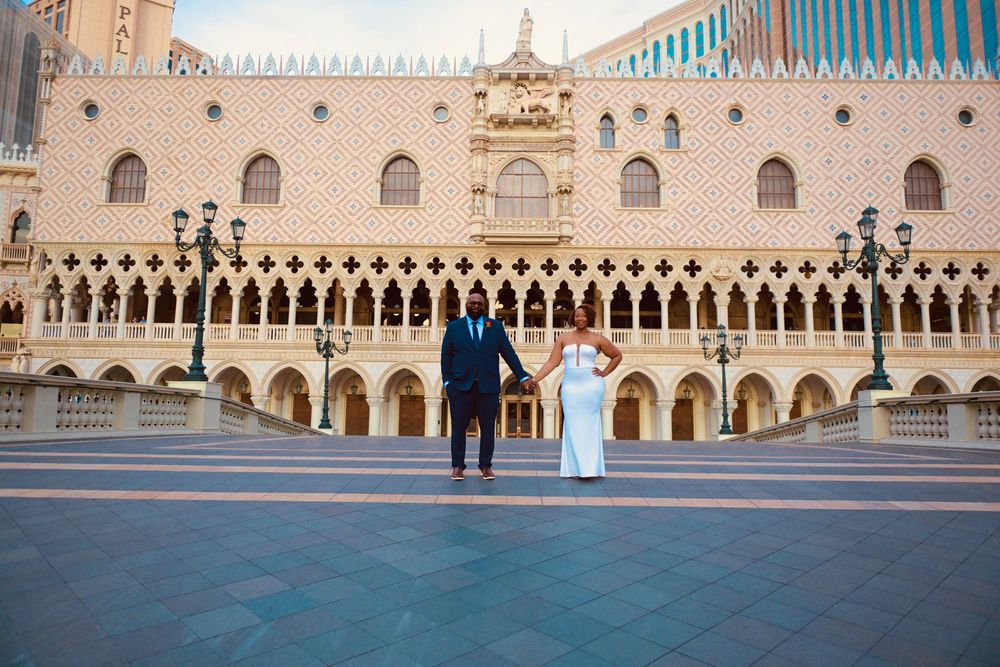 Couple in wedding attire posing in front of the Venetian Resort in Las Vegas on their wedding day.