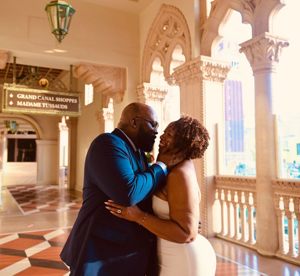 Couple sharing a romantic kiss at The Venetian Las Vegas, bride in white gown and groom in blue suit.