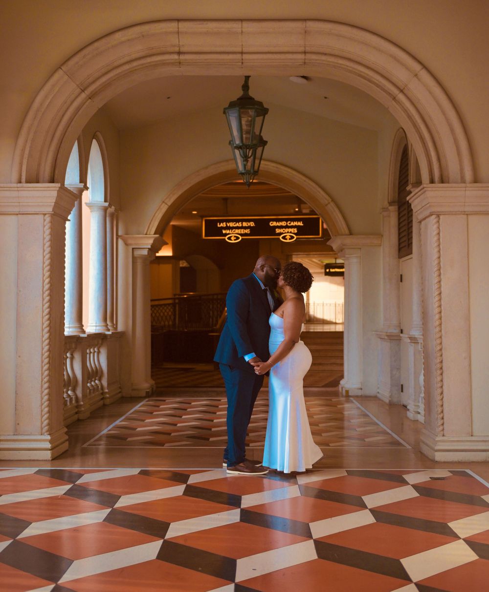 Newlywed couple sharing a romantic moment in an elegant arched hallway at The Venetian Las Vegas.