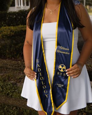 Graduate wearing a navy and gold Radiology RTR graduation stole