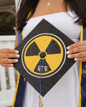 Decorated graduation cap featuring a rhinestone radiation symbol with RTR initials.