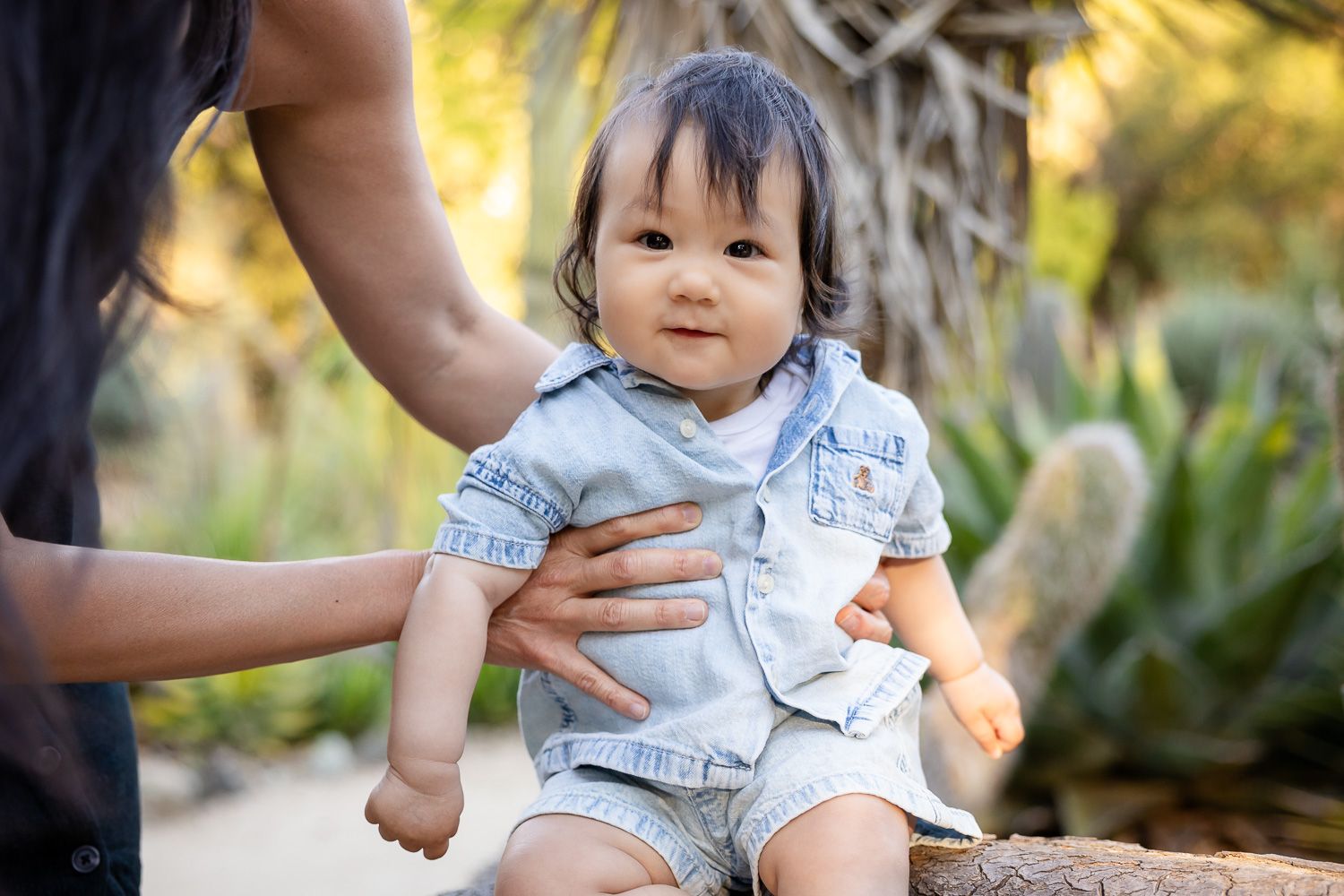 Adorable baby smiling while being held by parent in a lush garden in Palo Alto outdoor photoshoot