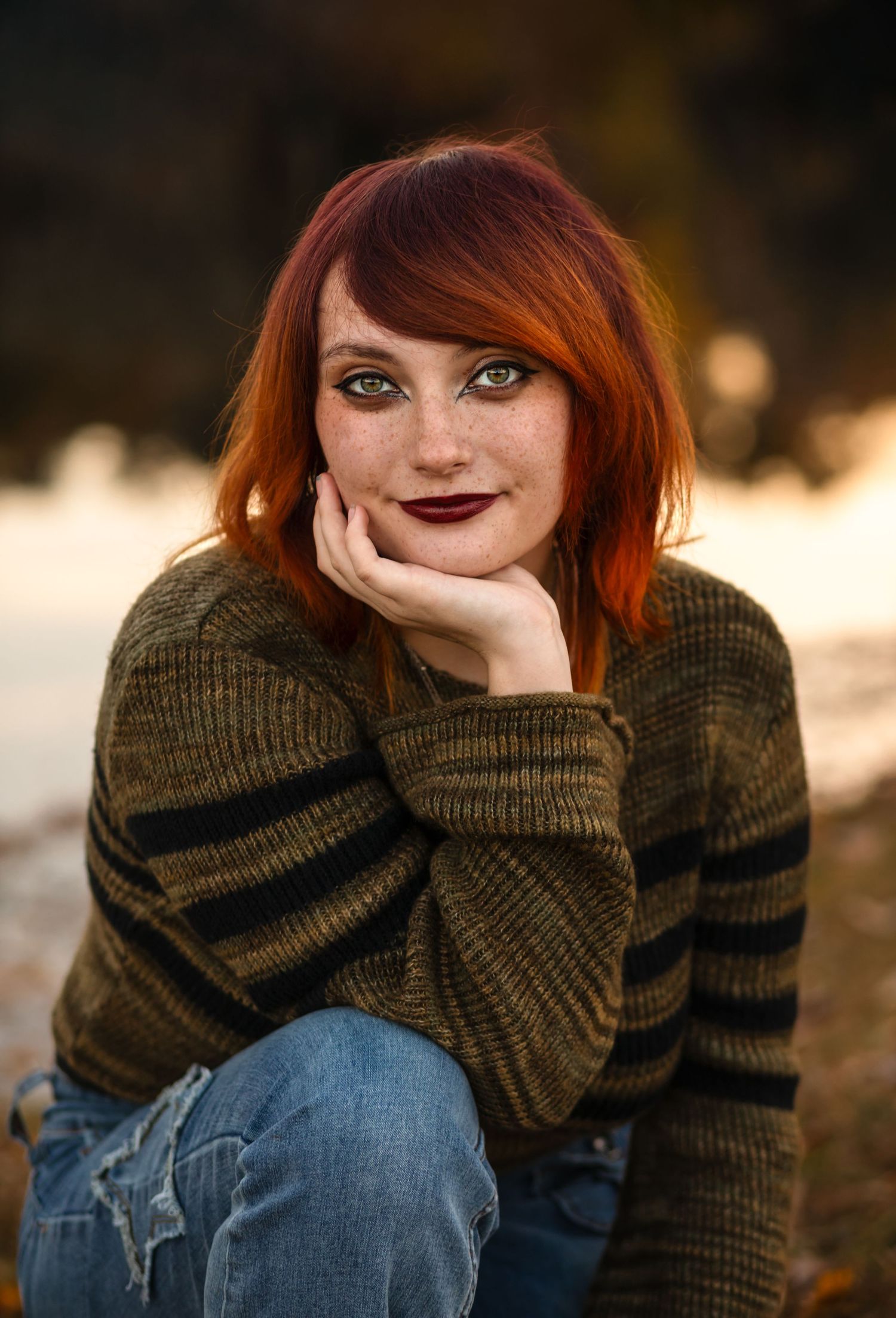 Portrait of a striking young woman with red hair and green eyes, wearing an olive sweater by Charlottesville senior and family photographer.