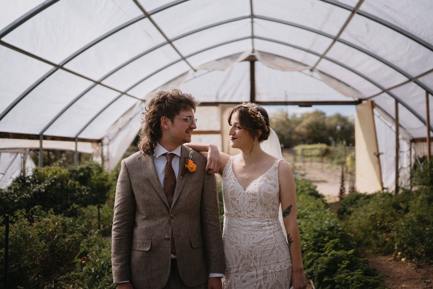 Bride and groom share a romantic moment inside a greenhouse on their wedding day at Old Town Farm in New Mexico