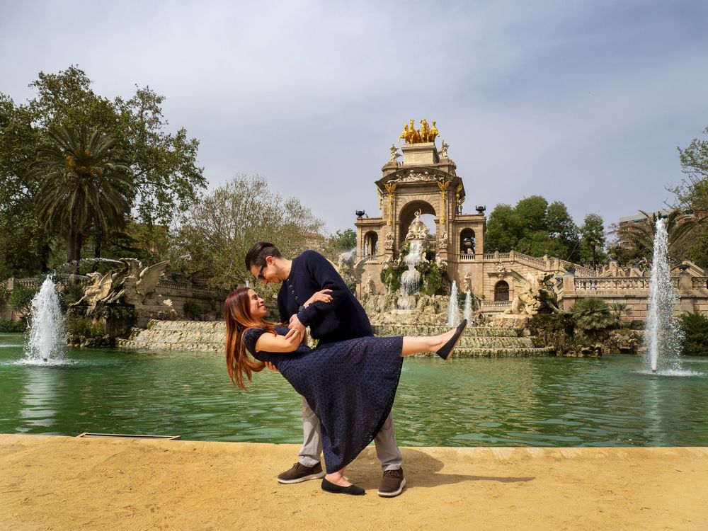 Couple sharing a romantic dip kiss in front of the Cascada fountain in Parc de la Ciutadella, Barcelona.