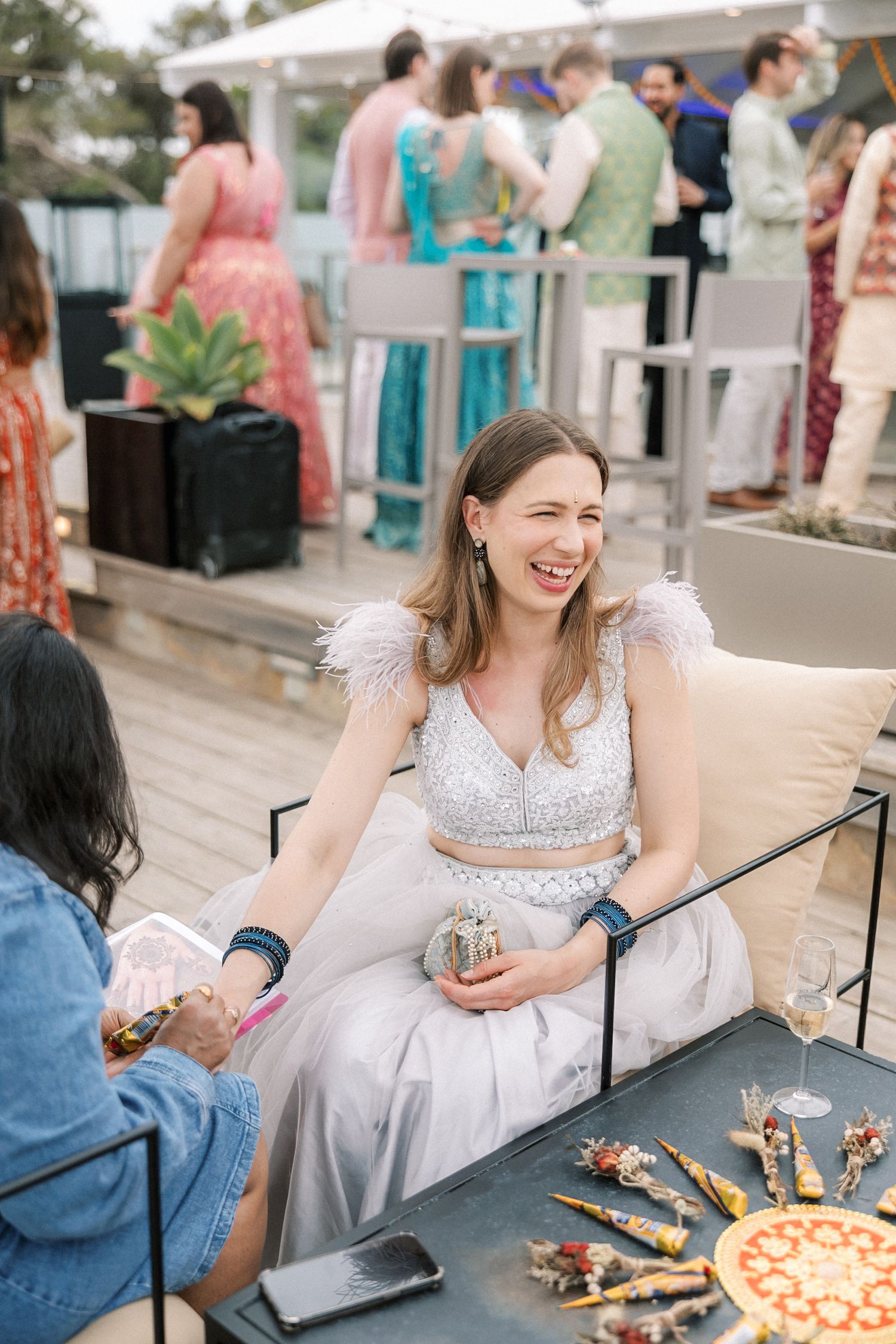 guest  smiling during the Mehndi celebration by the sea in Cascais.