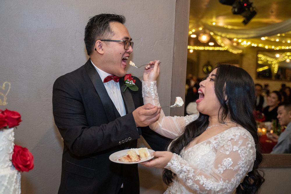 Joyful cake cutting moment as bride and groom feed each other at The Buttes at Reflections, photographed by N&D Media Production.