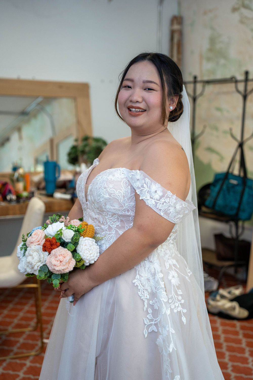 Detail shot of bride holding a custom hand-sewn fabric bouquet during her wedding, photographed by N&D Media Production.