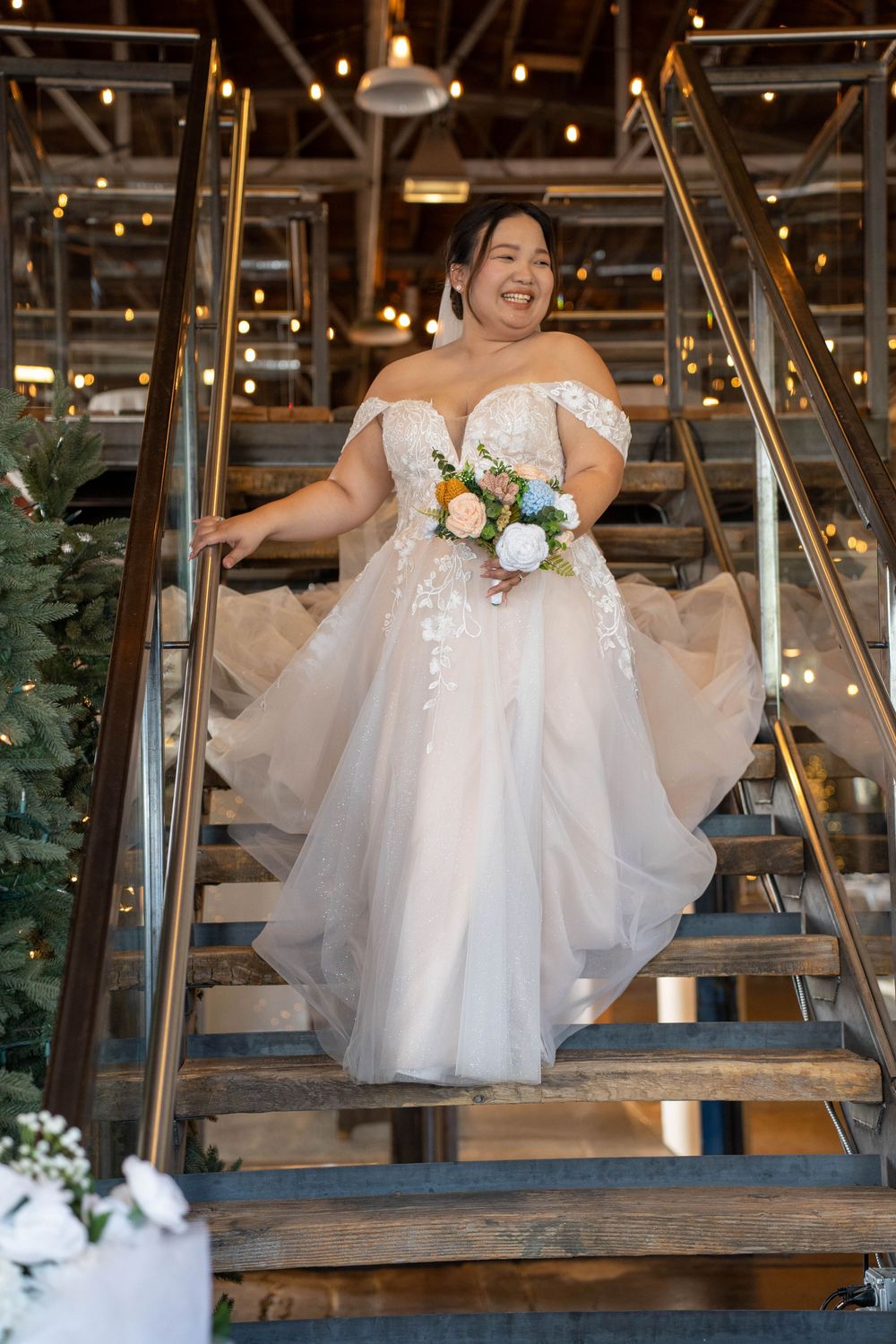 Bride walking down the stairs in her wedding dress at The Hitching Post in Springville, UT, captured by N&D Media Production.