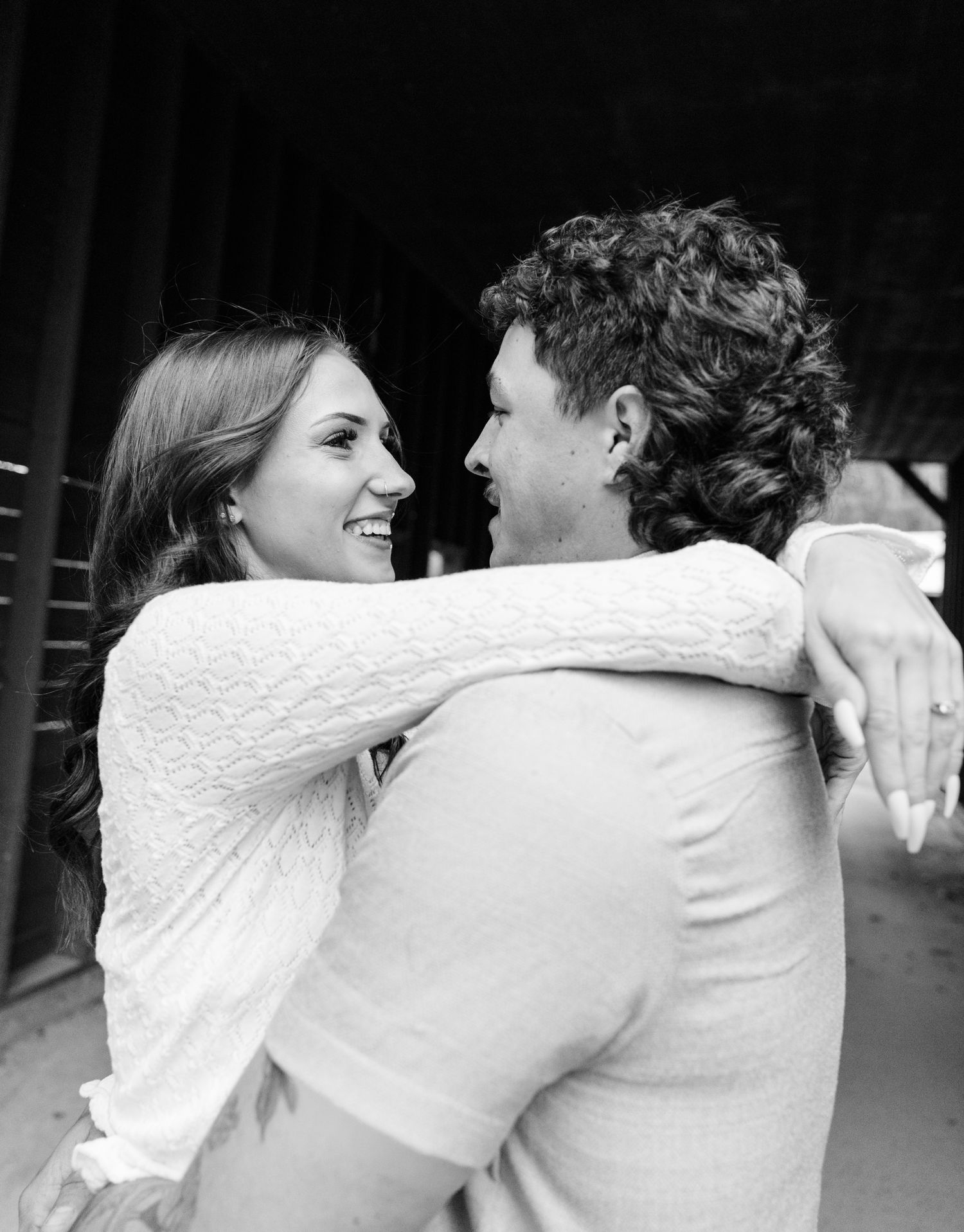 Black and white photo of a man and woman standing apart indoors near windows with bare trees visible outside.