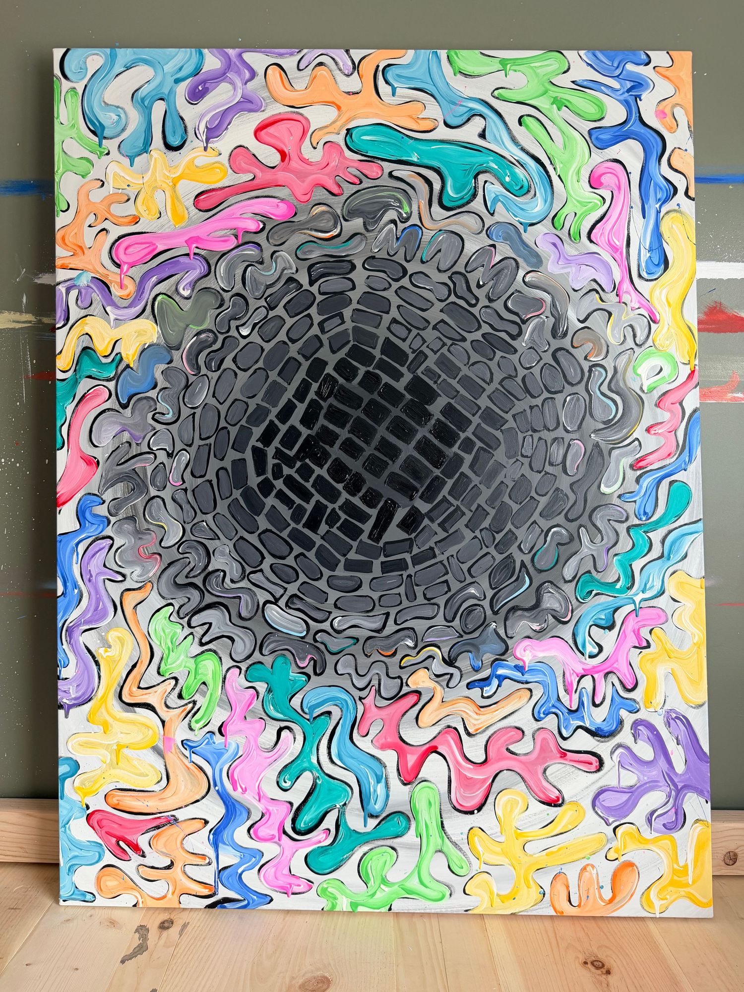 Vibrant psychedelic eye painting on black canvas with yellow, blue, and red abstract patterns in a wooden frame.