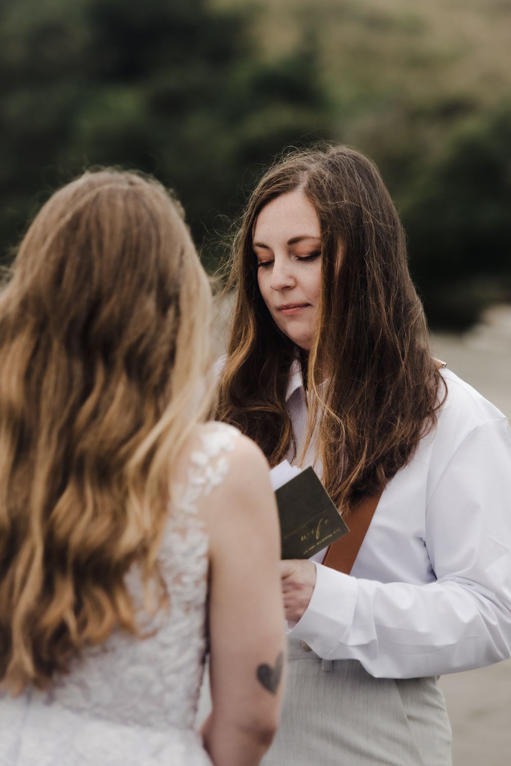 Close up of a brunette bride reading her vows to her bride during their Oregon Coast elopement