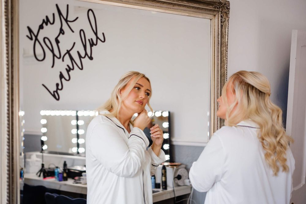 bride getting ready in mirror at Knowle country house