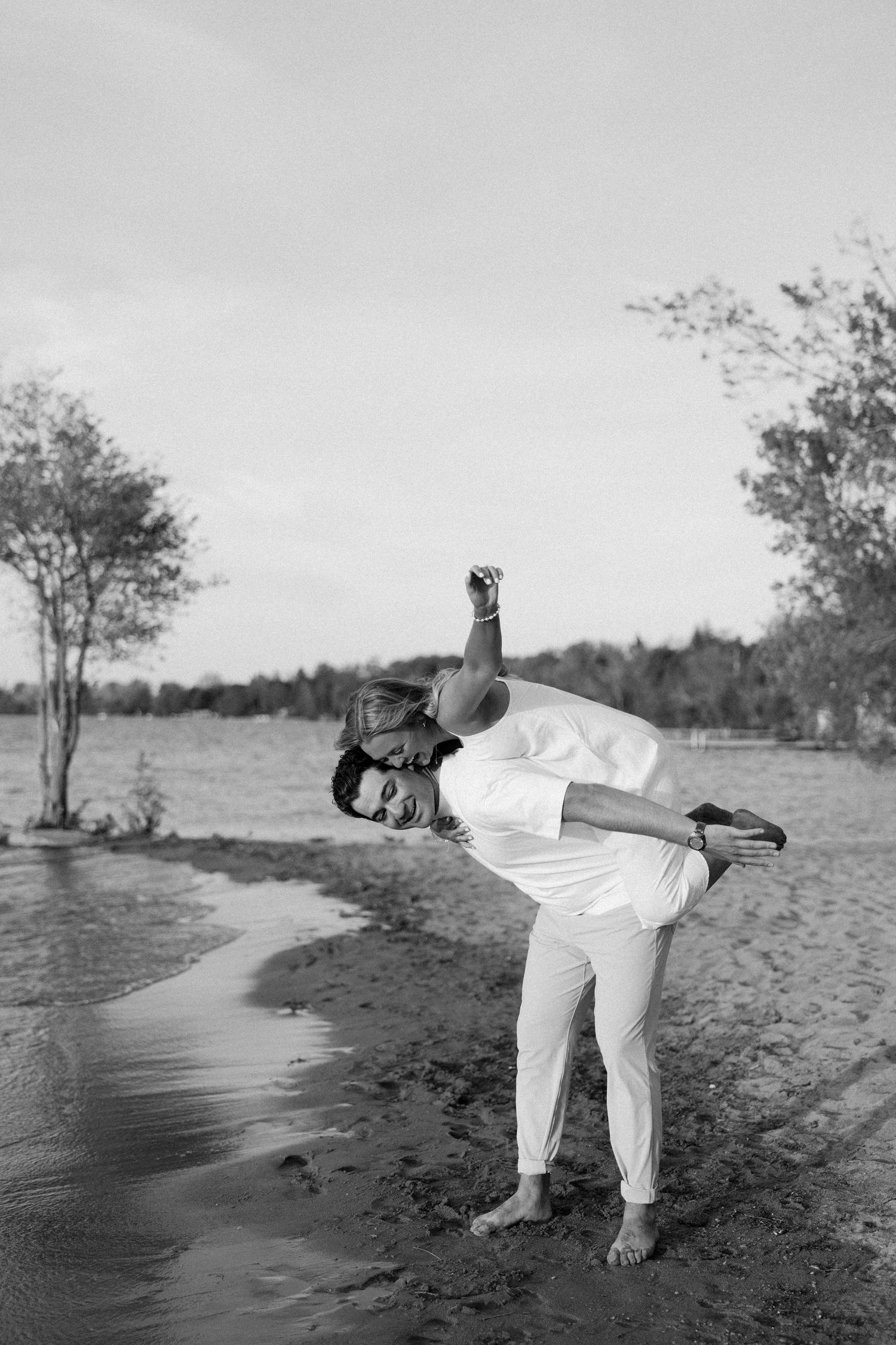 Fun candid engagement photos on the beach in Georgina, Ontario