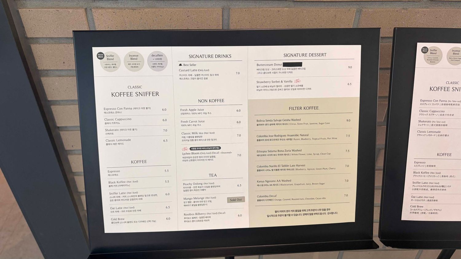 Menu board for Koffie Snapper cafe displaying signature drinks, non-coffee options, and desserts with prices.
