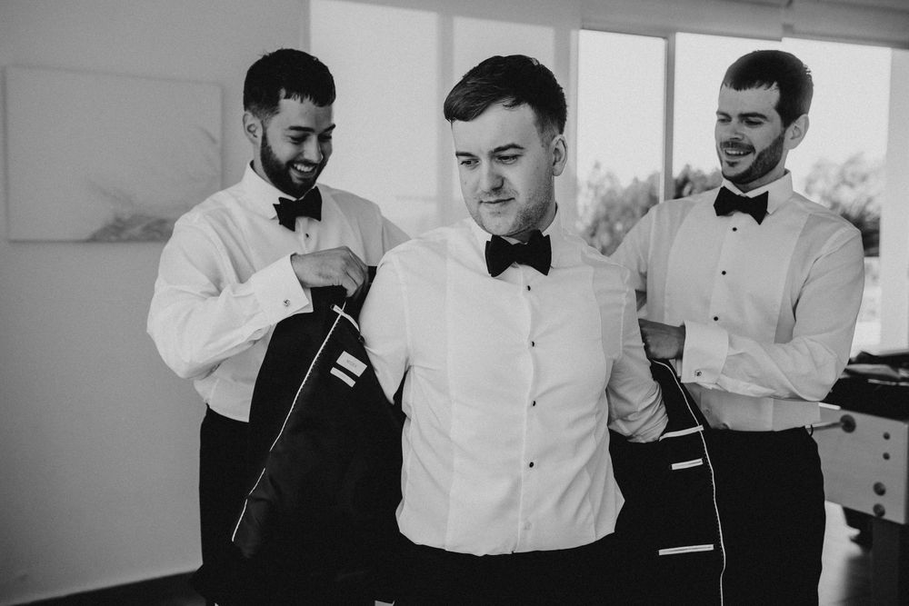 Black and white photo collage showing groomsmen laughing and getting ready for a wedding celebration.