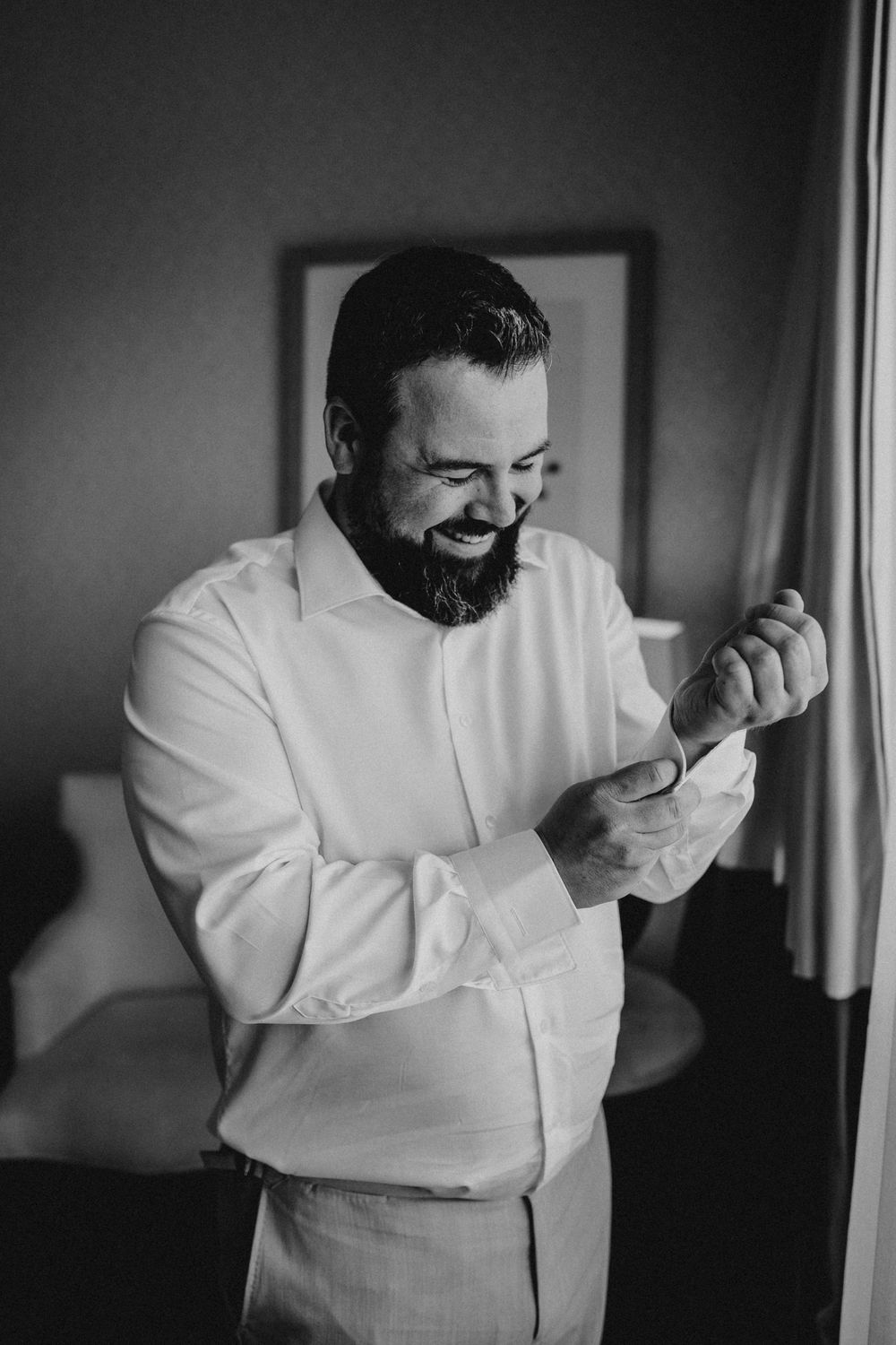 A person in a white dress shirt laughs and smiles in a series of black and white candid photographs.