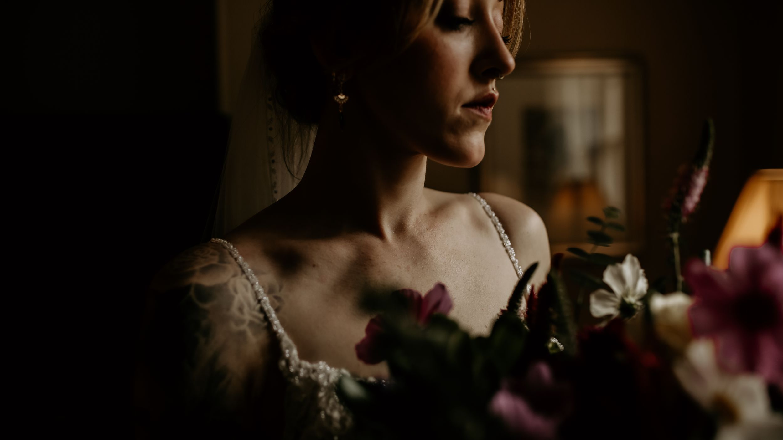 Intimate wedding portrait with moody lighting and dramatic shadows.