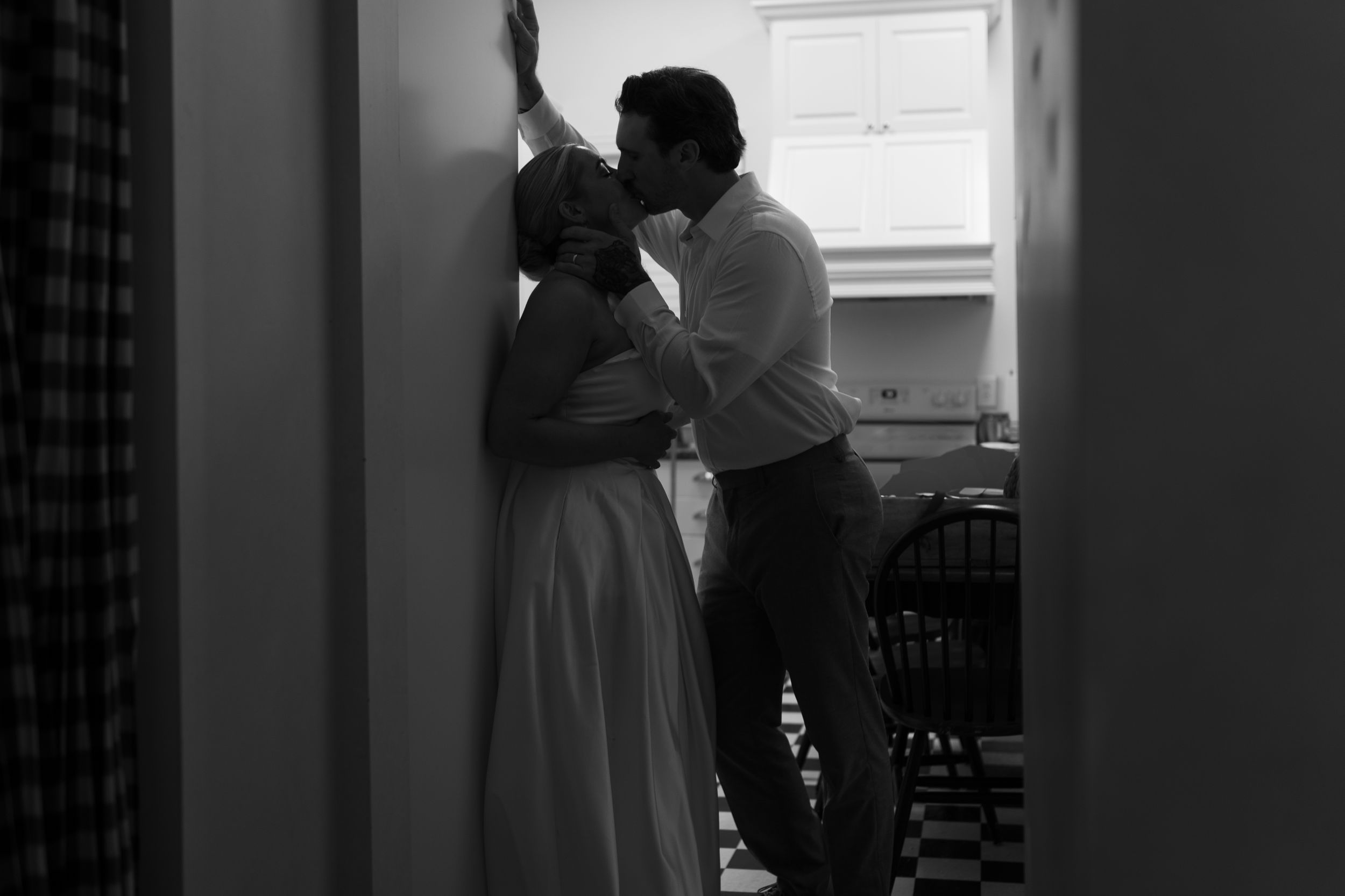 A tender moment captured in a sunlit room with dramatic shadows.