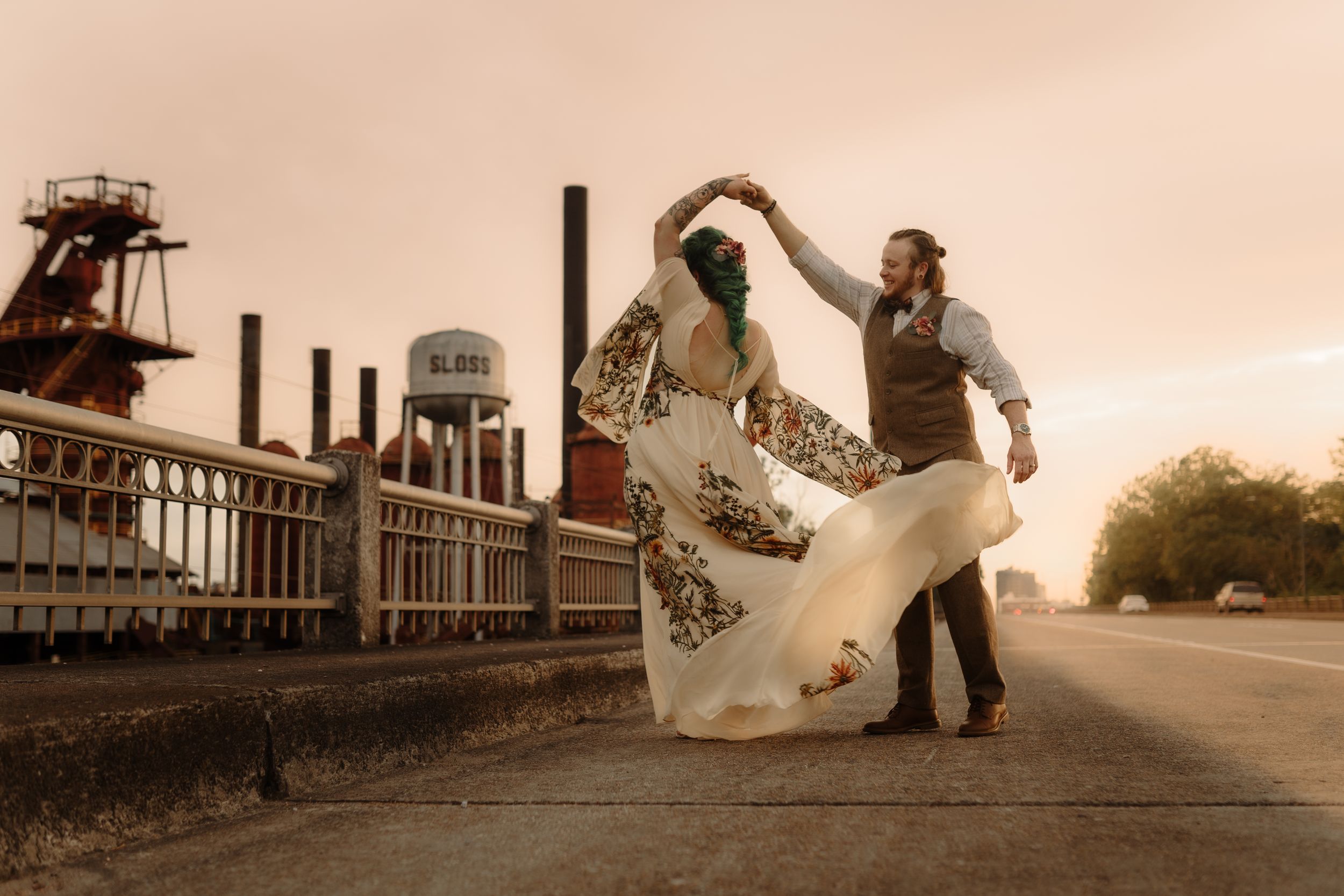 Wedding couple posing dramatically at industrial location during sunset.