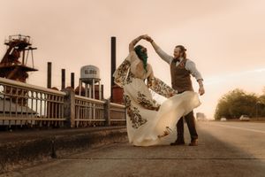 Wedding couple posing dramatically at industrial location during sunset.