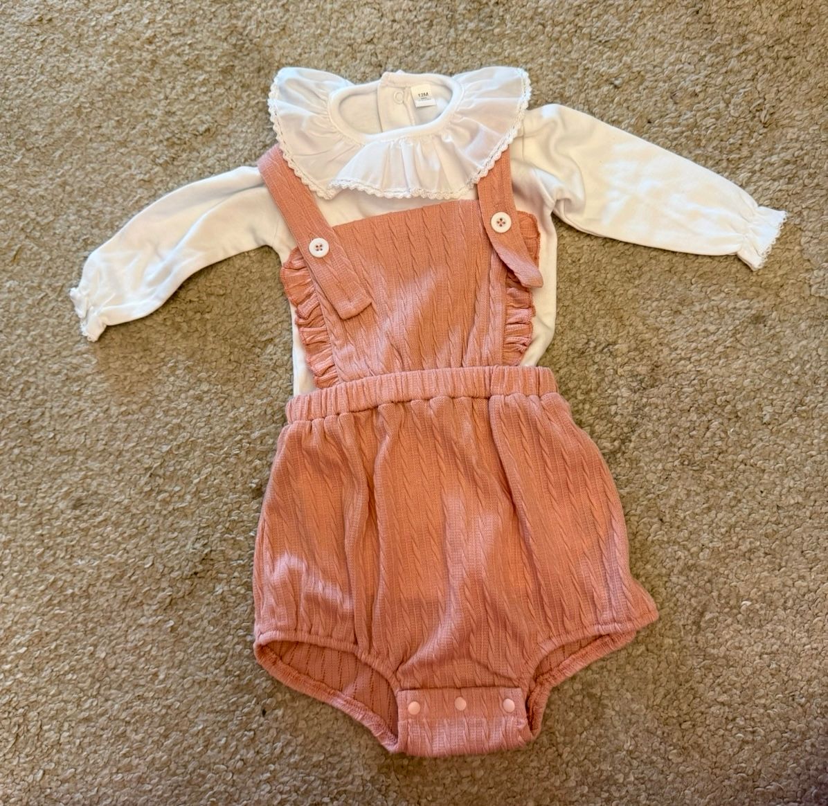 Peach colored baby romper with white collar detail.
