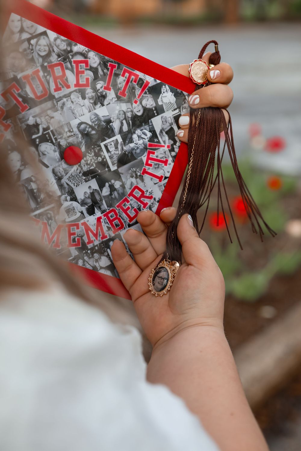 Hands holding a decorated graduation cap with tassel and memories collage.