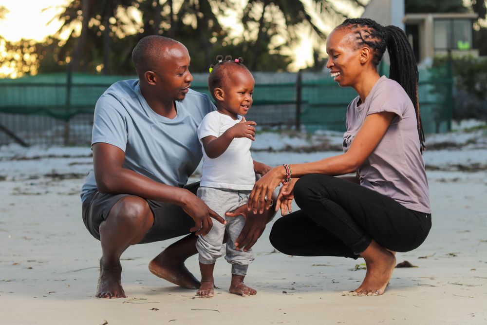 Parents with their child pose for a photo both parents looking at the child