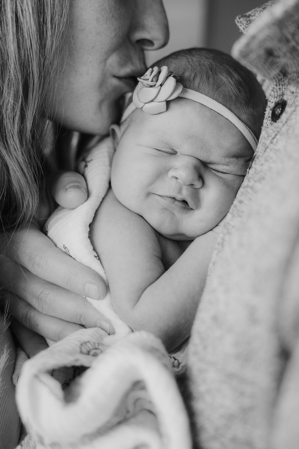 Black and white close-up portrait of sleeping newborn with soft lighting.