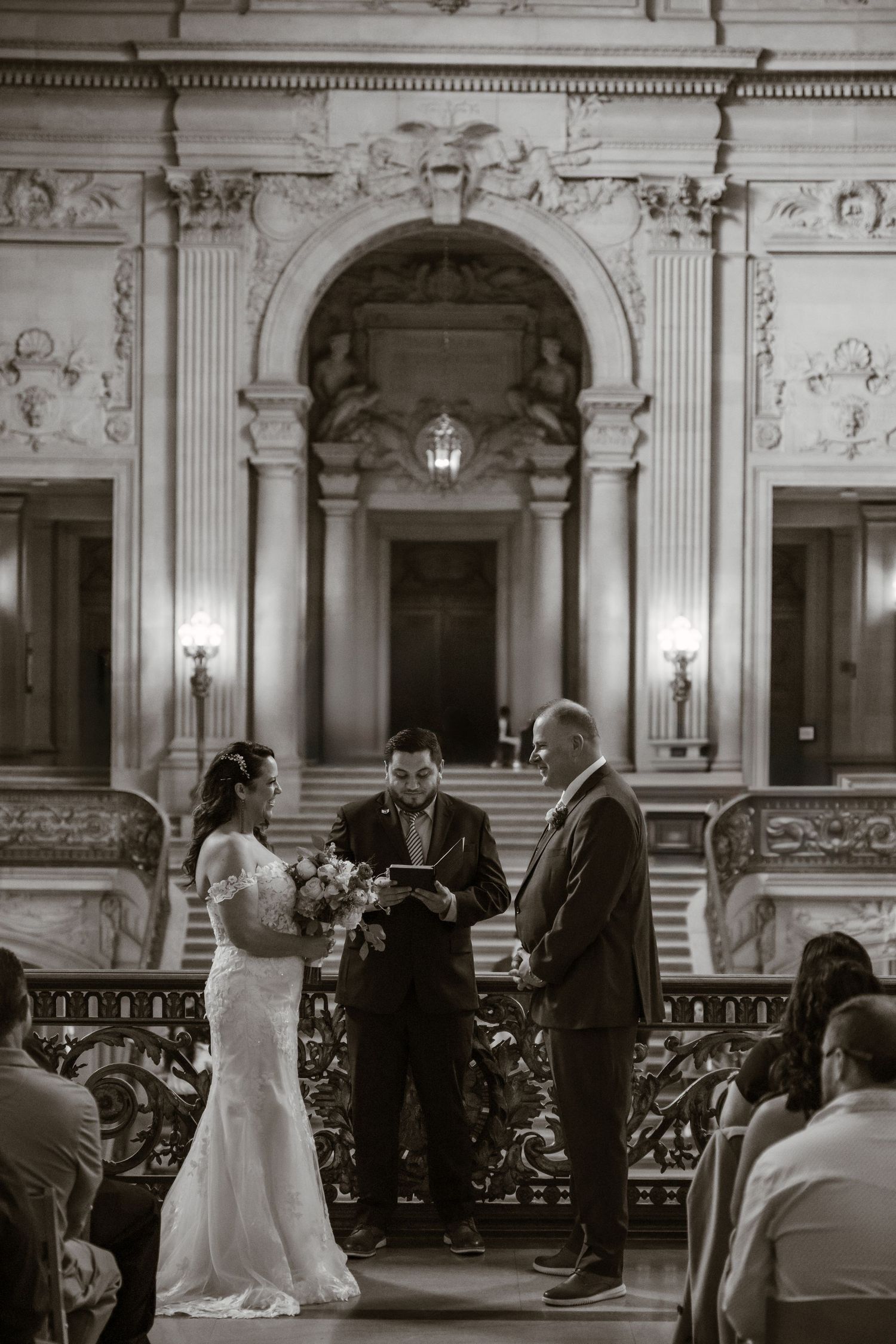 An elegant black and white wedding ceremony sequence inside a grand historic building with ornate architecture.